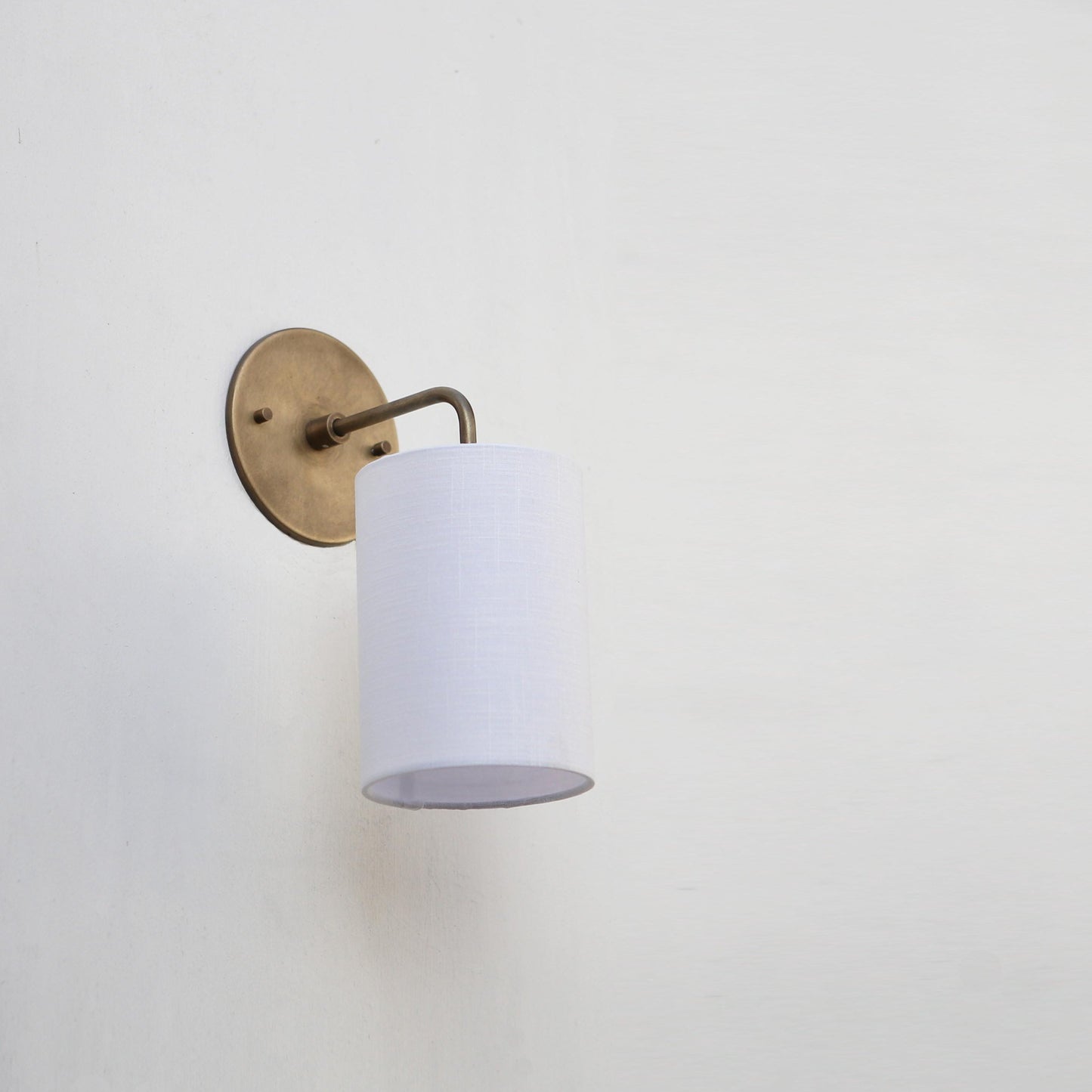 Curved Arm Brass Wall Sconce with Linen Drum Shade