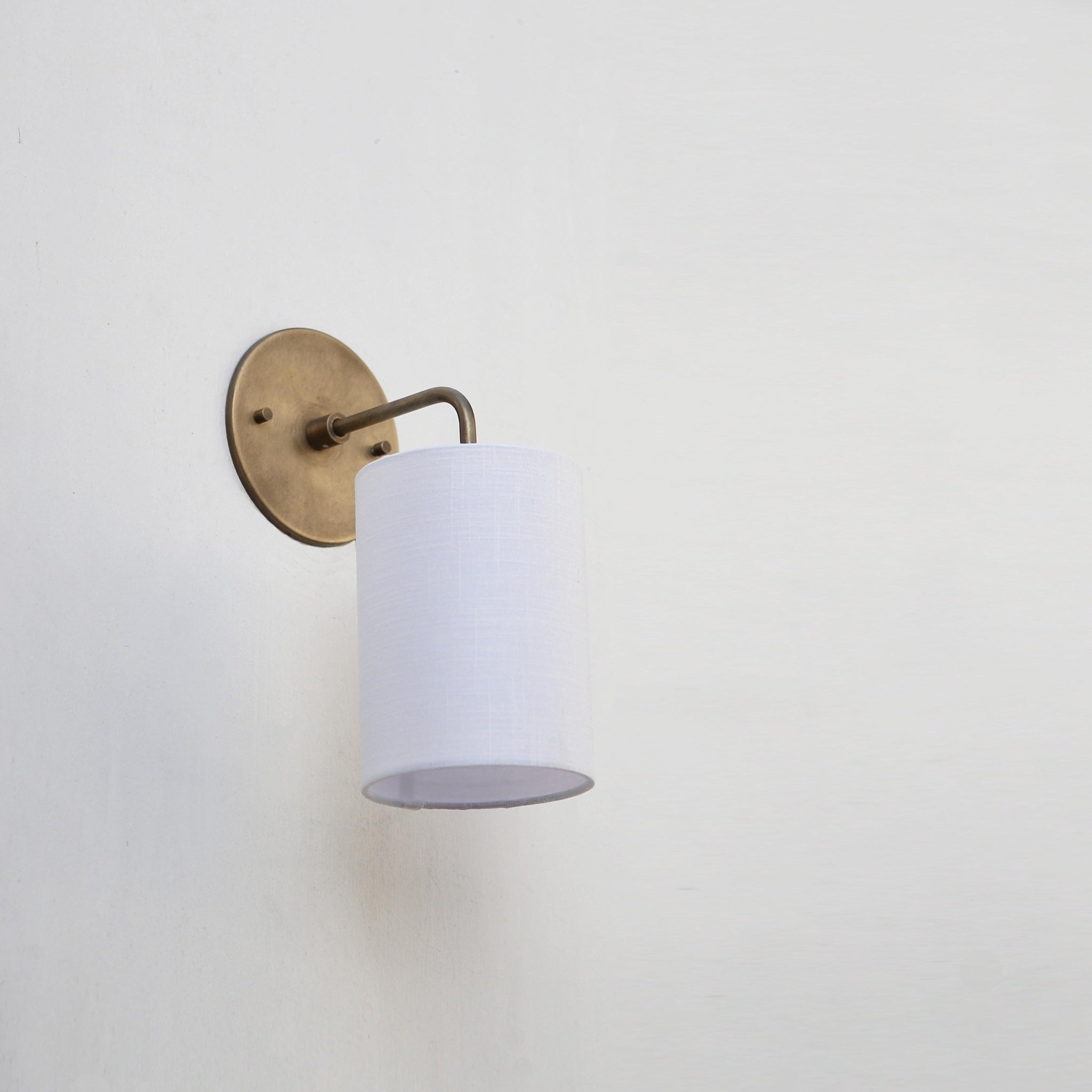 Curved Arm Brass Wall Sconce with Linen Drum Shade