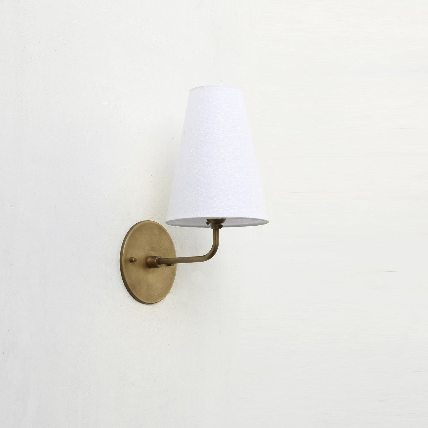 Curved Arm Brass Wall Sconce with Tapered Linen Shade
