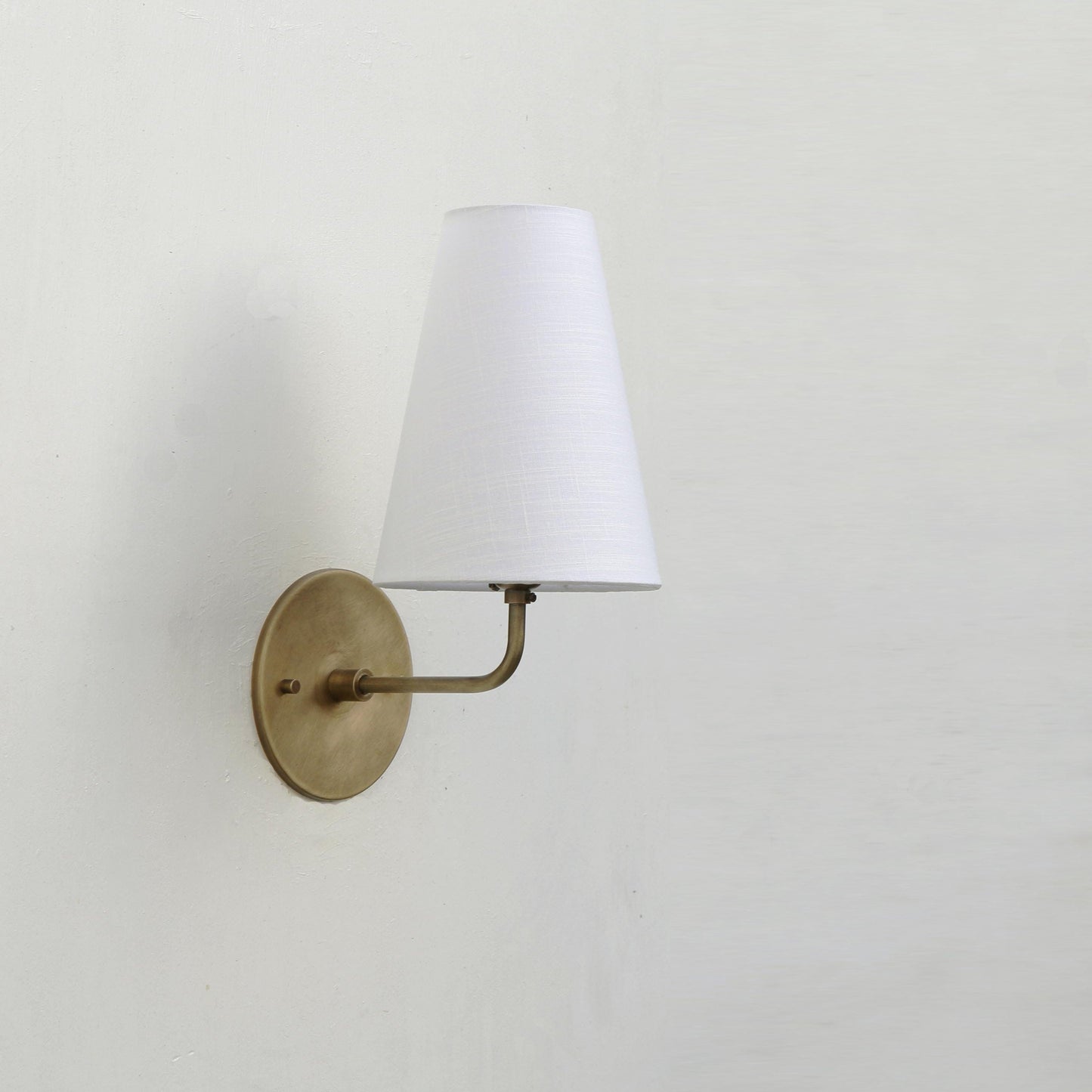 Curved Arm Brass Wall Sconce with Tapered Linen Shade