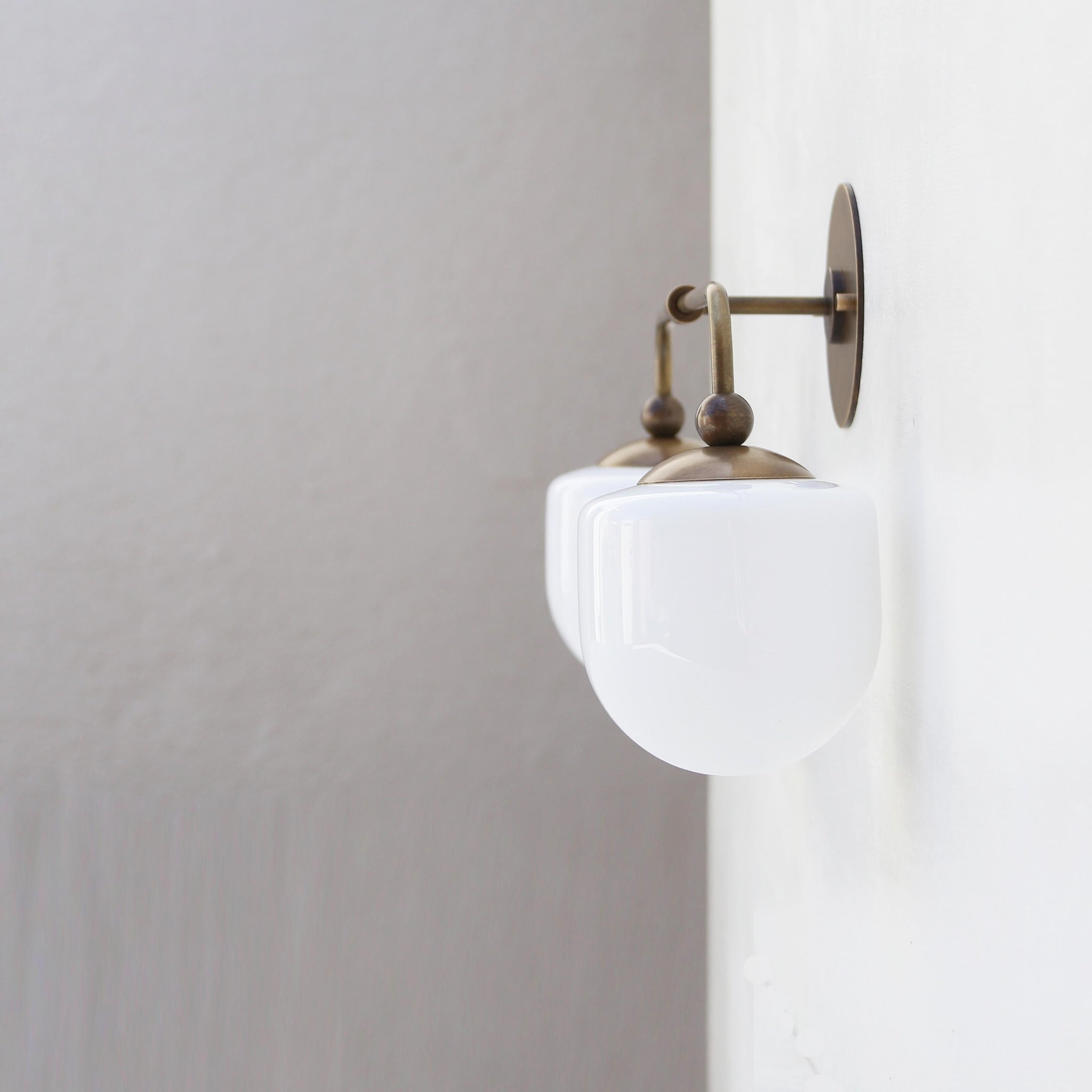 Two-Light Brass Wall Sconce with Opal Glass Globe Shades